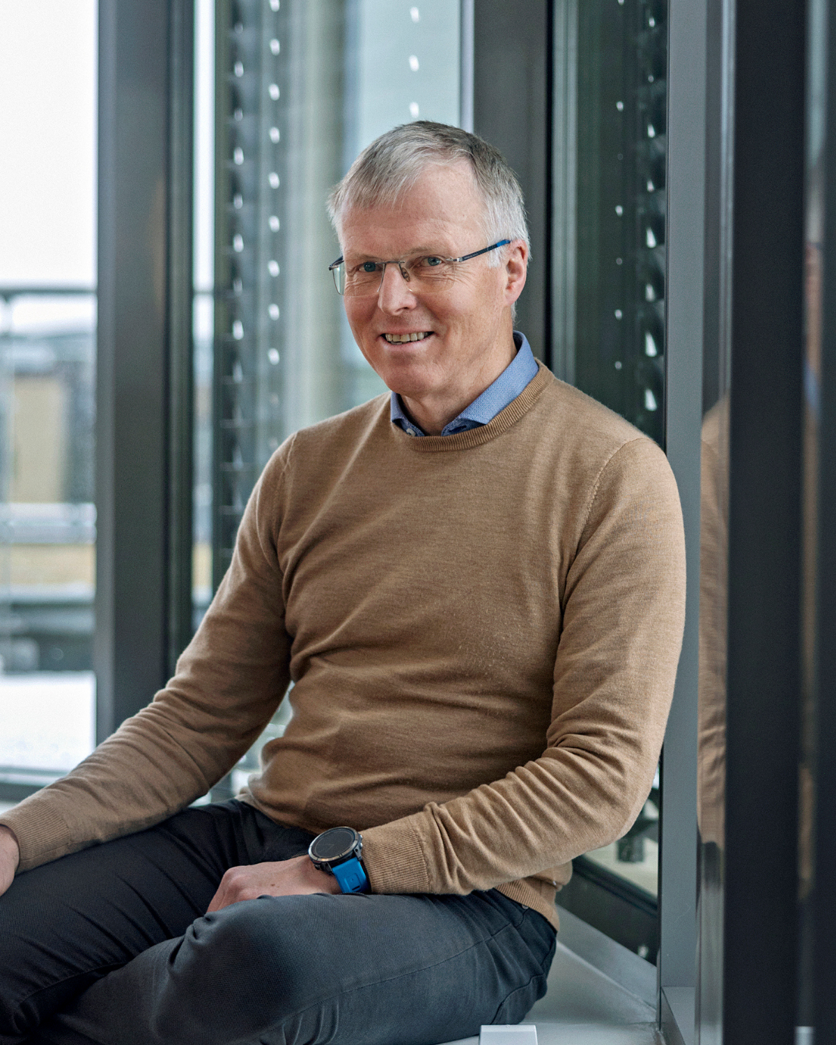 The photo shows Morten Sollerud, CEO of Norilia. He is sitting on a chair, looking at the camera. He is wearing a brown sweater. This is a portrait photo.